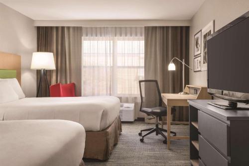 a hotel room with two beds and a desk at Country Inn & Suites by Radisson, Dubuque, IA in Dubuque