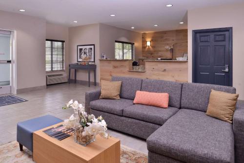 a living room with a couch and a table at Country Inn & Suites by Radisson, Omaha Airport, IA in Omaha