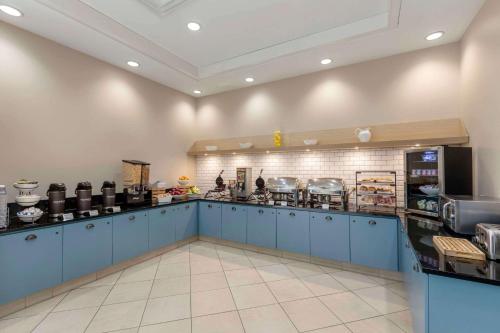 a large kitchen with blue cabinets and a counter at Country Inn & Suites by Radisson, Elk Grove Village-Itasca in Elk Grove Village