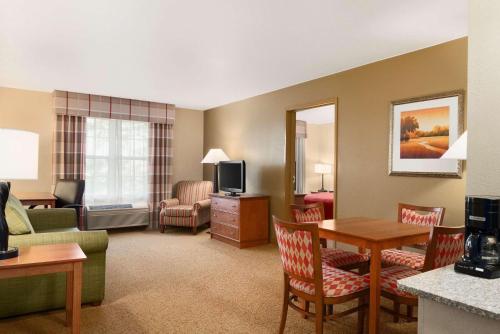 a hotel room with a living room with a couch and a television at Country Inn & Suites by Radisson, Sycamore, IL in Sycamore