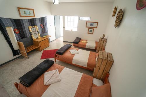Habitación con 4 camas y sala de estar. en AdventureKeys Surf Yoga Cowork en Taghazout