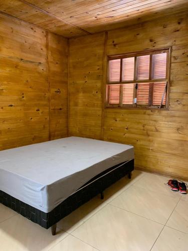 a bedroom with a bed in a wooden room at CASA DO BOSQUE in Imbituba