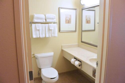 a bathroom with a toilet and a sink with towels at Country Inn & Suites by Radisson, Peoria North, IL in Peoria