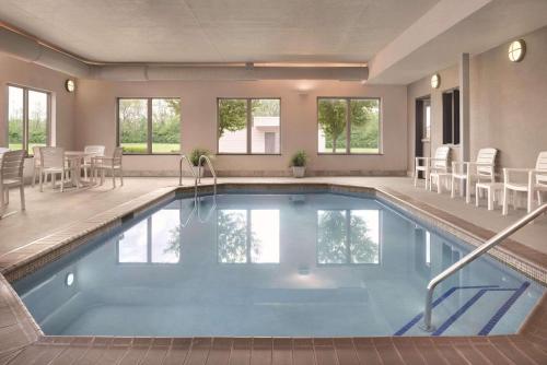 a swimming pool in a house with chairs and tables at Country Inn & Suites by Radisson, Springfield, IL in Springfield