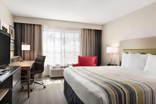 ロムオービルにあるCountry Inn & Suites by Radisson, Romeoville, ILのベッド、デスク、コンピュータが備わる客室です。