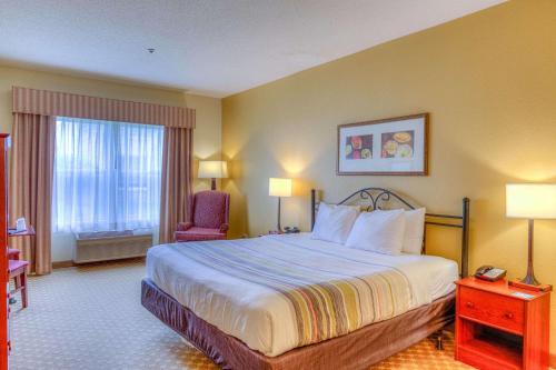 a hotel room with a bed and a chair at Country Inn & Suites by Radisson, Crystal Lake, IL in Crystal Lake