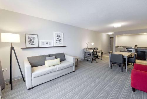 a living room with a couch and a dining room at Country Inn & Suites by Radisson, Tinley Park, IL in Tinley Park
