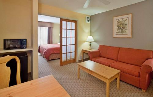 een hotelkamer met een rode bank en een bed bij Country Inn & Suites by Radisson, Bloomington-Normal West, IL in Bloomington