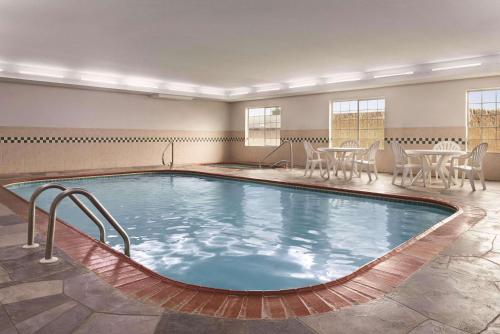 a large indoor pool with chairs and a table at Country Inn & Suites by Radisson, Michigan City, IN in Michigan City