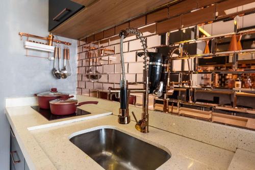 una cocina con fregadero de acero inoxidable y encimera en MS906 Studio Encantador na Bela Vista, en São Paulo