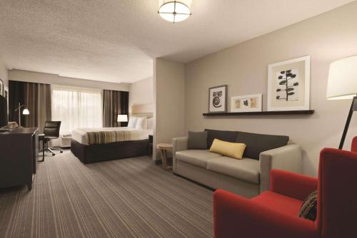 een hotelkamer met een bank en een bed bij Country Inn & Suites by Radisson, Indianapolis South, IN in Indianapolis