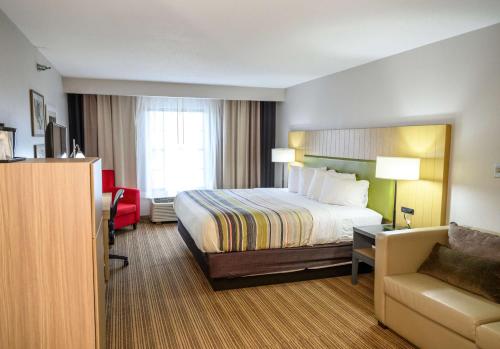 una camera d'albergo con letto e sedia di Country Inn & Suites by Radisson, Greenfield, IN a Greenfield
