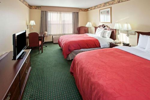 a hotel room with two beds and a flat screen tv at Country Inn & Suites by Radisson, Elkhart North, IN in Elkhart