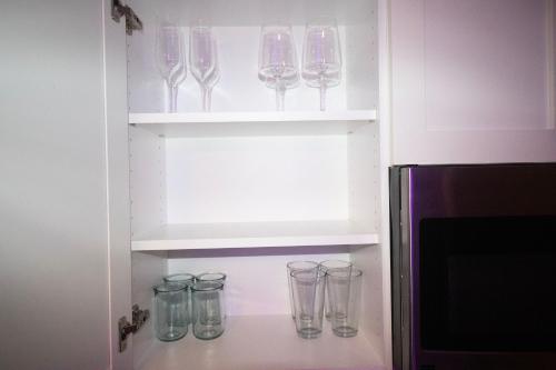 una fila de copas de vino sentadas en estanterías en un refrigerador en Ocean Way One Bedroom, en Los Ángeles