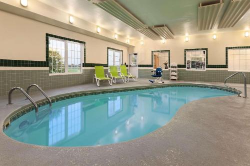 una piscina en una habitación de hospital con un niño caminando alrededor de ella en Country Inn & Suites by Radisson, Salina, KS en Salina