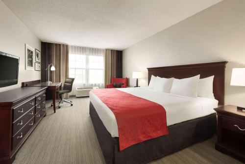 a hotel room with a large bed and a desk at Country Inn & Suites by Radisson, Kansas City at Village West, KS in Kansas City