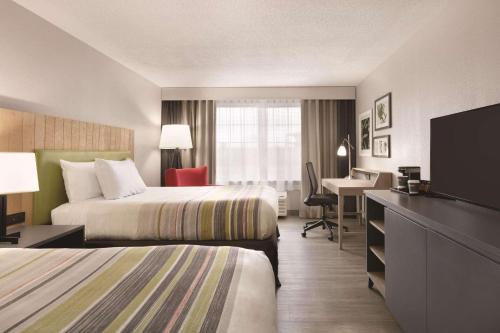 Habitación de hotel con 2 camas y escritorio en Country Inn & Suites by Radisson, London, KY, en London