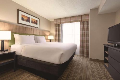 a hotel room with a large bed and a television at Country Inn & Suites by Radisson, Georgetown, KY in Georgetown