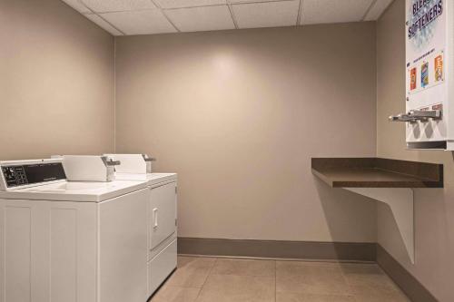 a laundry room with a washer and dryer on a wall at Country Inn & Suites by Radisson, Georgetown, KY in Georgetown