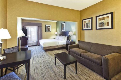 a hotel room with a couch and a bed at Country Inn & Suites by Radisson Benton Harbor-St Joseph MI in Benton Harbor