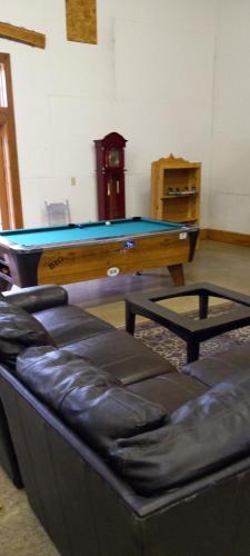 a ping pong table in a living room with a couch at spacious former store 