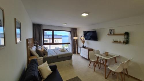 Cet appartement comprend une chambre avec un lit et un salon avec une table. dans l'établissement Nova Patagonia Apart Bariloche, à San Carlos de Bariloche
