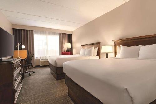 Habitación de hotel con 2 camas y escritorio en Country Inn & Suites by Radisson, Grand Rapids East, MI, en Grand Rapids