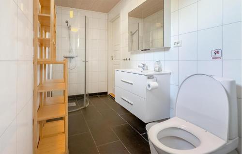 Baño blanco con aseo y lavamanos en Stunning Home In Farsund With House Sea View, en Farsund