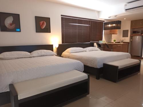 two beds in a hotel room with a kitchen at Playa Blanca in Playa Blanca