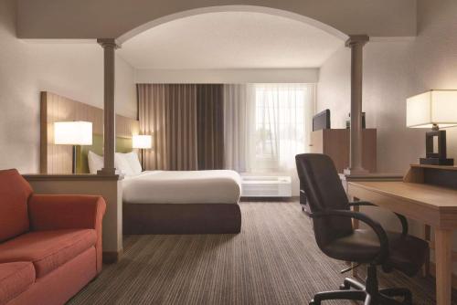 Pokój hotelowy z łóżkiem i biurkiem w obiekcie Country Inn & Suites by Radisson, Eagan, MN w mieście Eagan