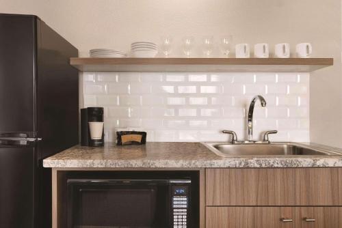 eine Küche mit einer Spüle und einer Arbeitsplatte in der Unterkunft Country Inn & Suites by Radisson, Shoreview, MN in Mounds View