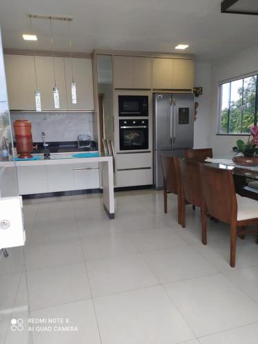 a kitchen with a table and chairs and a refrigerator at Sobrado aconchegante. in Cascavel