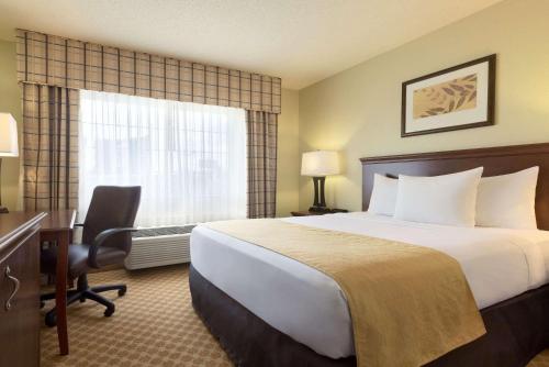 A bed or beds in a room at Country Inn & Suites by Radisson, Rochester, MN