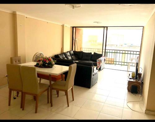 a living room with a table and a couch at Habitación amoblada con servicios Rio mar in Barranquilla