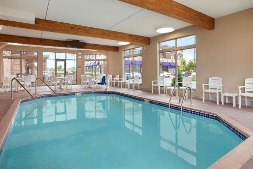 a swimming pool in a hotel with tables and chairs at Country Inn & Suites by Radisson, Roseville, MN in Roseville
