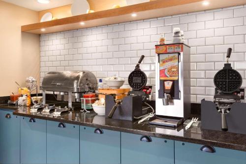 a kitchen with a counter top with a mixer and food at Country Inn & Suites by Radisson, Rochester South, MN in Rochester