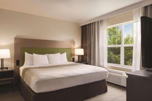 Tempat tidur dalam kamar di Country Inn & Suites by Radisson, Cottage Grove, MN