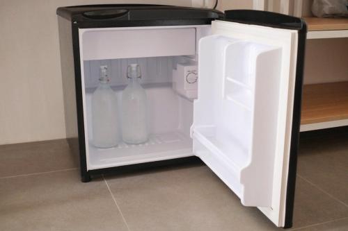 an open refrigerator with two milk bottles in it at Aginana Villas in san juan la union
