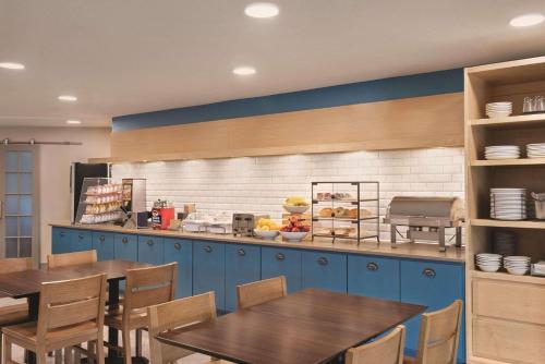 a restaurant with two tables and a counter with food at Country Inn & Suites by Radisson, Northfield, MN in Northfield
