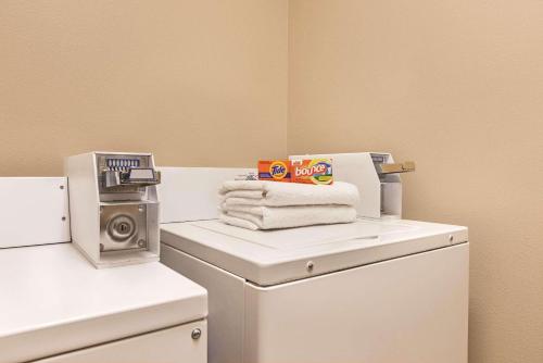 a laundry room with a stack of towels on a washing machine at Country Inn & Suites by Radisson, Albert Lea - Austin in Albert Lea