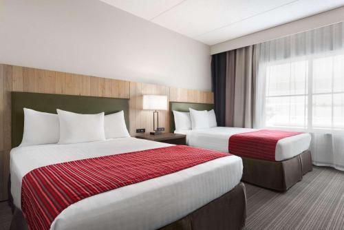a hotel room with two beds and a window at Country Inn & Suites by Radisson, Duluth North, MN in Duluth