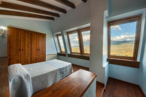 1 dormitorio con 1 cama y 2 ventanas en Villarrobles de Altamira, en Cortijos Nuevos