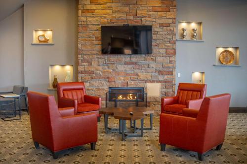 a waiting room with chairs and a fireplace at Country Inn & Suites by Radisson, Bemidji, MN in Bemidji