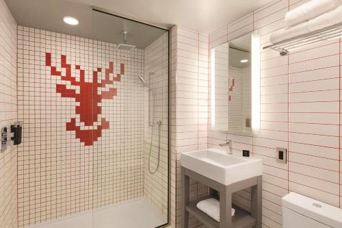 a bathroom with a sink and a shower with a mirror at Radisson Red Minneapolis Downtown in Minneapolis