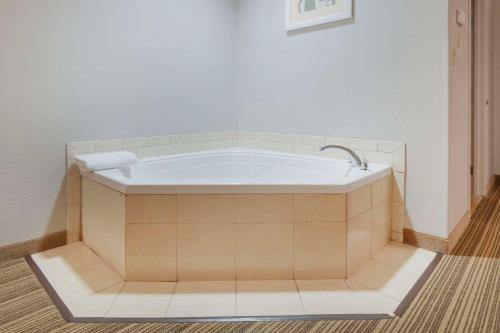 uma banheira na casa de banho com piso em azulejo em Country Inn & Suites by Radisson, Columbia, MO em Columbia