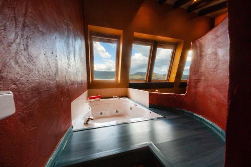 uma banheira num quarto com 2 janelas em Villarrobles de Altamira em Cortijos Nuevos