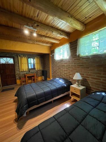 a large bedroom with two beds and a table at Alojamiento ¨El Puente¨ en El Bolsón, para dos personas. in El Bolsón