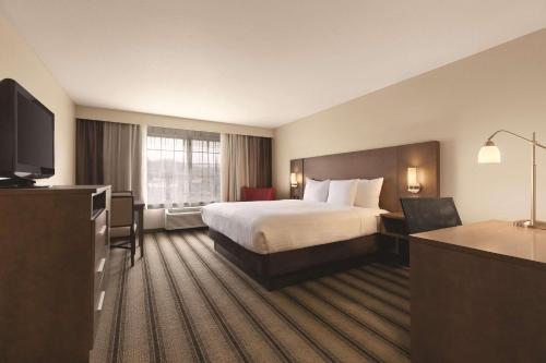 ビリングスにあるCountry Inn & Suites by Radisson, Billings, MTのベッドとテレビが備わるホテルルームです。