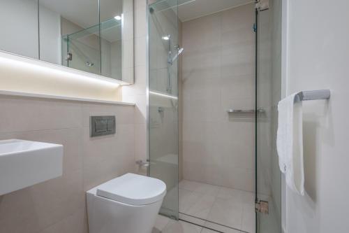 a bathroom with a shower and a toilet and a sink at Central Location! Boutique 2BR Apartment with Pool & BBQ near South Bank and City in Brisbane