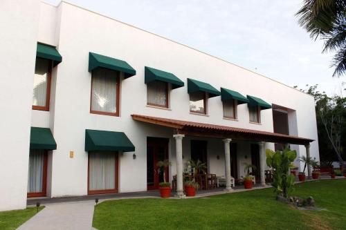 un edificio con toldos verdes a su lado en Radisson Hotel Cuernavaca en Cuernavaca